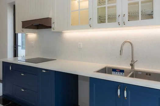 a freestanding compact countertop dishwasher placed on a kitchen counter connected to a faucet, small apartment kitchen, soft window light, editorial product photography, no people