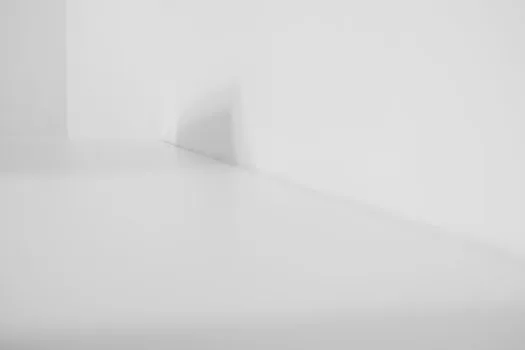 a robot vacuum auto-empty dock station with a dust bag compartment open, placed in a corner of a modern home, clean minimal interior, soft daylight, editorial product photography, no people