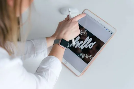 a tablet displaying a colorful drawing app on screen with an apple pencil resting beside it on a desk, soft natural window light, close-up, editorial product photography, shallow depth of field