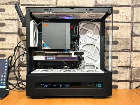 a high-end gaming desktop pc with side glass panel showing a large graphics card and rgb lighting, on a desk next to a monitor running a game