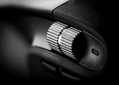 close-up macro of a gaming mouse optical sensor glowing on the underside, dark background, detailed product photography, shallow depth of field