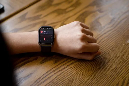 close-up of a smartwatch screen showing heart rate and sleep data on a wrist, soft indoor light, editorial photography, shallow depth of field
