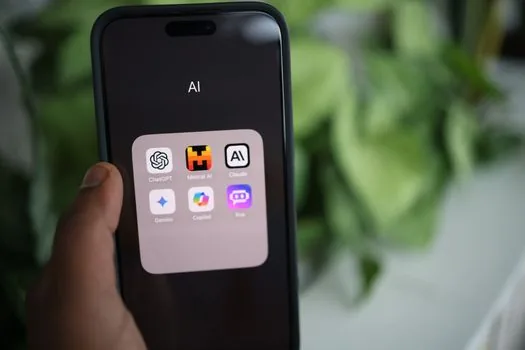 person checking AI privacy settings on smartphone beside laptop