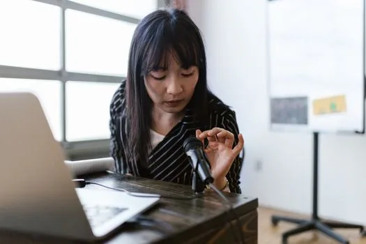 person checking laptop microphone with video meeting app