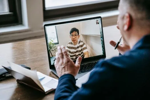 video meeting app settings showing camera device selection on a Windows 11 laptop, realistic over the shoulder photo