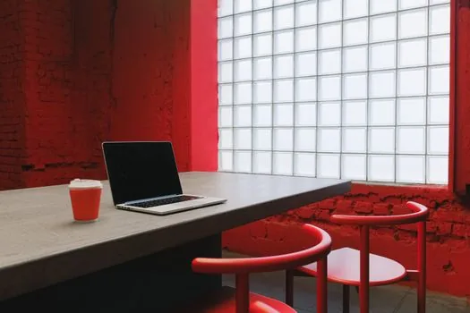 Windows 11 laptop showing camera privacy settings and a video meeting black preview on a clean desk, realistic tech support photo