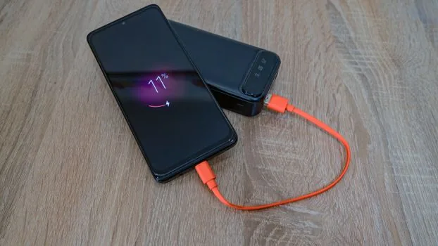 Android phone notification shade showing USB charging notification beside Windows 11 laptop