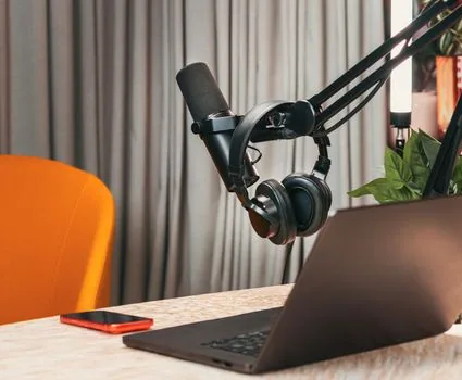 close-up of Windows 11 laptop sound input settings with a small external microphone on desk, user checking audio levels, realistic Korean home office, soft window light, no readable brand logos