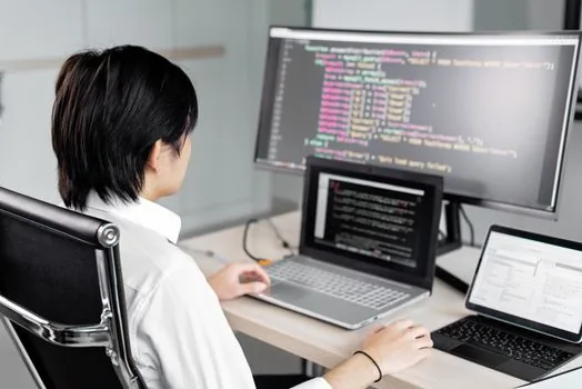 developer reviewing secure code findings and patch checklist on dual monitors, no readable code, realistic Korean tech office photo | 코드 취약점 검토와 패치 우선순위를 확인하는 장면