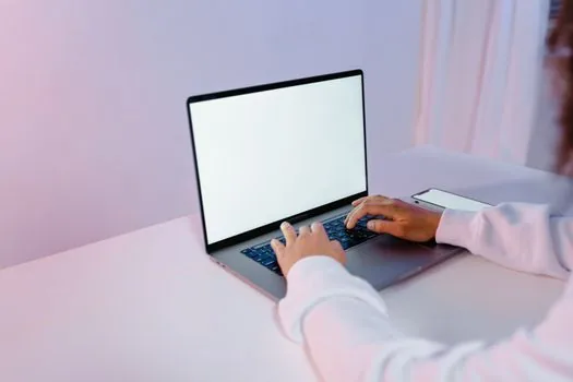Google account security checkup screen on laptop with smartphone two factor prompt, clean desk, Korean user reviewing account protection steps realistic photo