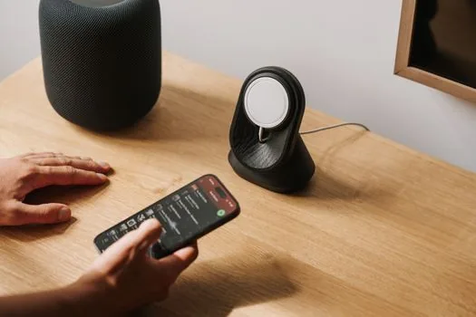 iPhone charging on desk away from direct sun, thermometer and simple battery checklist nearby, realistic practical tech photo | 고온을 피하고 충전 환경을 점검하는 장면