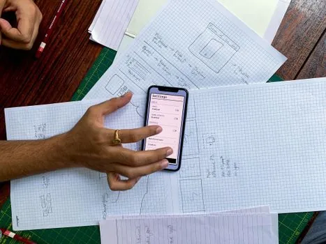 Korean iPhone user reviewing App Privacy Report and Photos permissions on a clean desk, privacy checklist notebook beside phone