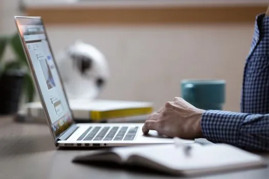 Korean office worker opening Windows 11 accessibility quick settings on laptop during online lecture, caption bar area visible, realistic clean desk, no readable private data | 윈도우 11 접근성 빠른 설정에서 라이브 캡션을 켜는 장면
