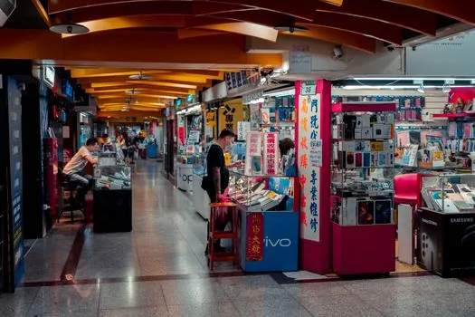 Korean shopper comparing Galaxy smartphone storage options and laptop RAM SSD specifications in a clean electronics store