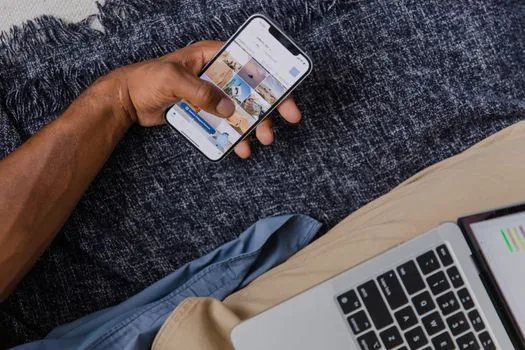 Person checking messenger PC device authentication management on smartphone beside laptop, privacy focused app settings photo | 카카오톡 PC 인증 기기와 자동 로그인 설정을 확인하는 장면