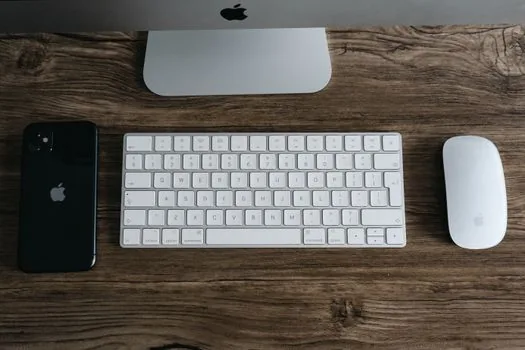 two iPhones side by side checking Contacts card with Apple Account email and Wi-Fi settings, bright realistic desk, privacy-safe screen | 연락처에 Apple 계정 이메일과 전화번호가 있는지 확인하는 장면
