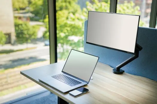 user dragging a Windows 11 app window to screen edge for split screen, laptop with two documents side by side, realistic Korean desk setup