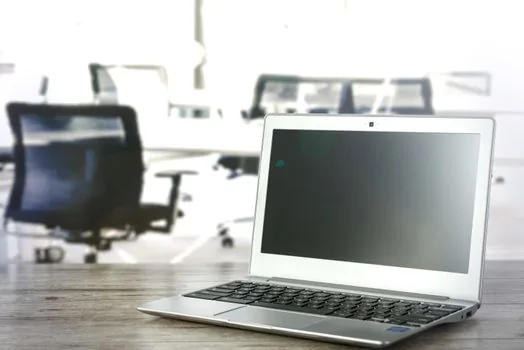 Windows 11 power mode and screen timeout settings on laptop in bright workspace