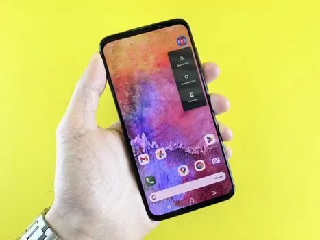 Android 설정 앱의 기본 앱 화면에서 브라우저 앱 항목을 선택하는 스마트폰 클로즈업, 밝은 책상, 실제 사용 장면