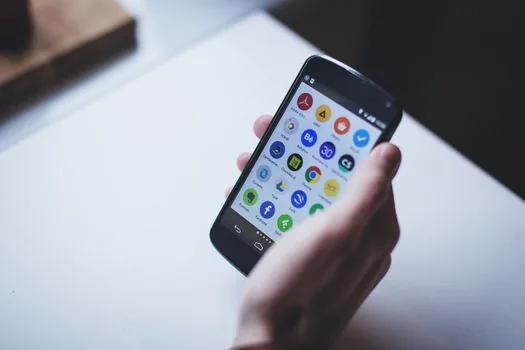 Android smartphone contacts list with duplicate names beside laptop showing Google Contacts merge and fix page, realistic Korean desk photo, no visible logos
