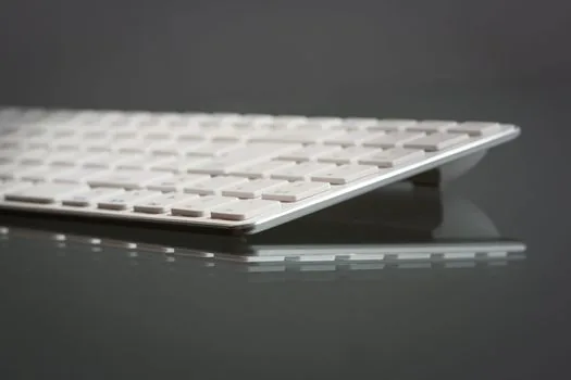 Bluetooth keyboard multi device keys, MacBook input source menu and nearby wireless accessories arranged for troubleshooting, realistic desk photo | 멀티페어링 키보드의 기기 전환 키와 맥북 입력 소스 메뉴를 함께 확인하는 장면