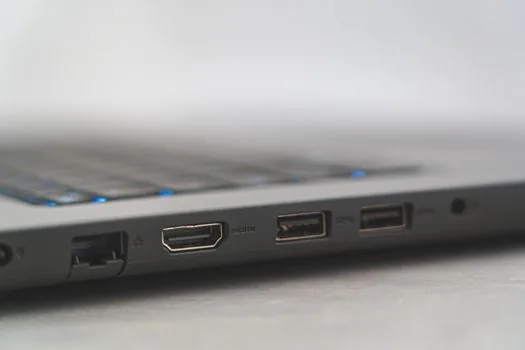 close-up of laptop USB-C ports with symbols, USB-C hub and HDMI cable beside it, realistic product photo