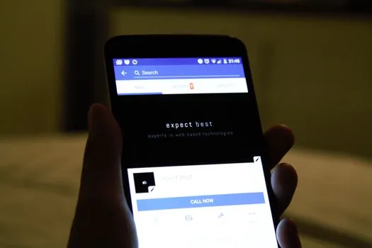 close-up of smartphone hand selecting report comment menu on social media app, privacy-safe blurred interface