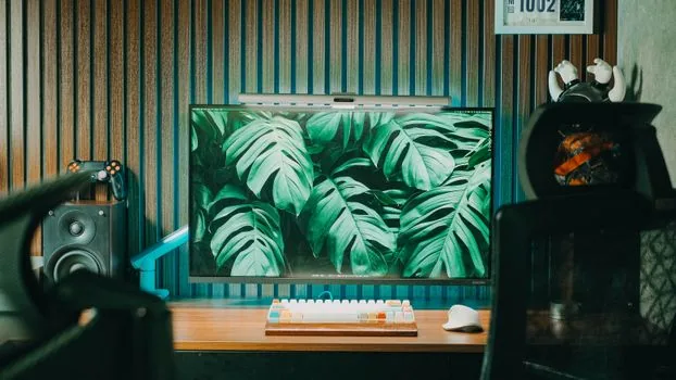 desktop monitor showing blurred YouTube player controls and autoplay toggle area, keyboard and mouse on desk, realistic photo