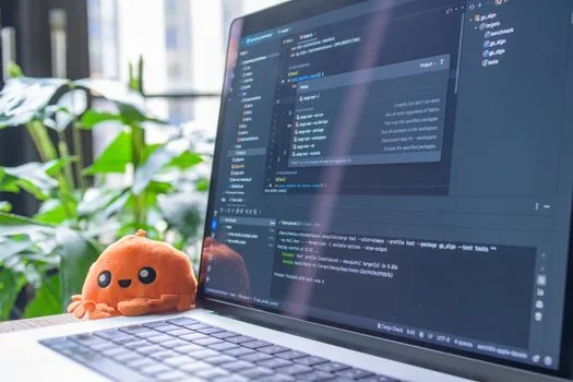 developer laptop showing terminal coding assistant and AI API dashboard in bright workspace