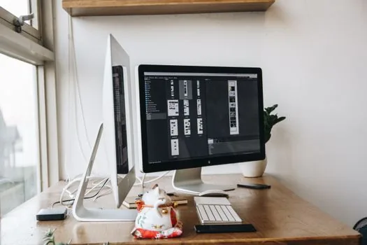 Korean desk with laptop and external monitor, user comparing grayscale monitor and normal laptop screen while checking display cable, realistic photo