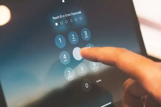 Korean employee reviewing privacy incident report form on desktop monitor with phone and security key on desk, realistic editorial photo, no readable text, no brand logos