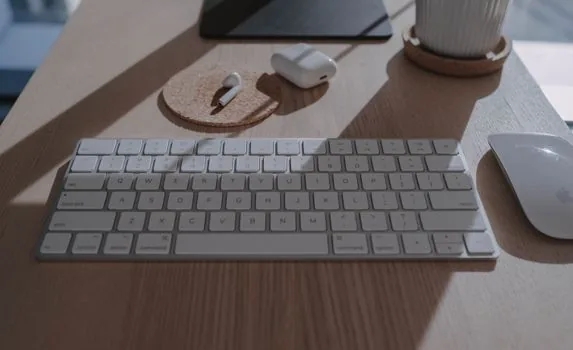 MacBook Bluetooth settings open beside slim wireless keyboard on a clean desk, pairing list visible, realistic Korean home office photo | 맥북 Bluetooth 설정에서 외장 키보드가 목록에 보이는지 확인하는 장면