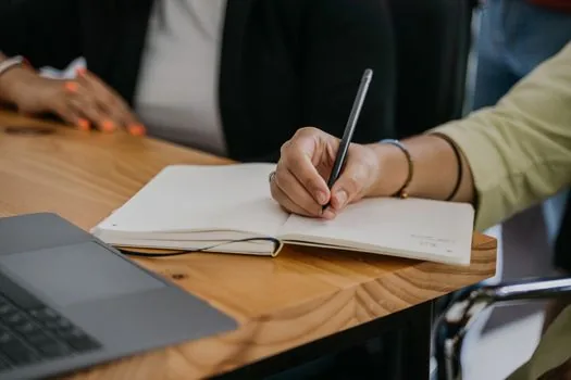 OneNote user copying unsynced meeting notes to a backup page before closing notebook, realistic laptop and notebook desk | 닫기 전에 미동기화 노트를 백업하는 장면
