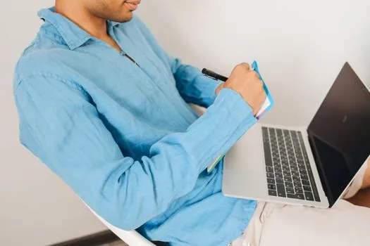 person checking Windows 11 contrast themes and accessibility settings on laptop with color swatches notebook, realistic bright desk photo