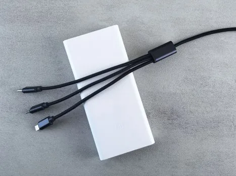 person cleaning laptop USB-C port with compressed air and arranging hub cables, realistic safe maintenance photo