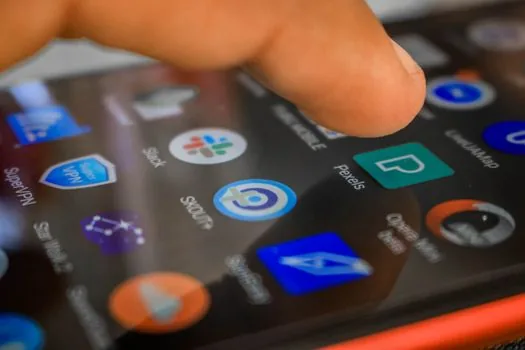 person comparing duplicate contact cards in Android Contacts app before tapping merge, bright desk, realistic editorial photo