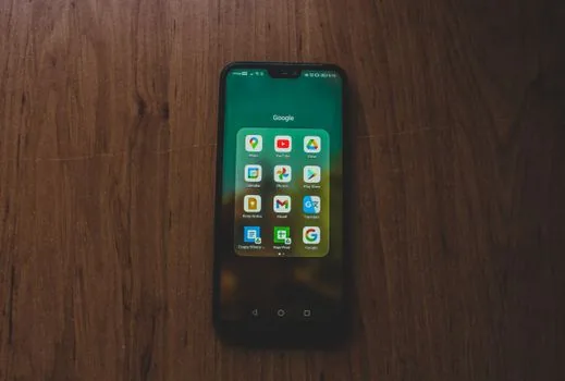 Play 스토어에서 Chrome 앱 설치 상태를 확인하는 Android 휴대폰과 노트북, 다운로드 버튼이 보이는 밝은 실사 장면