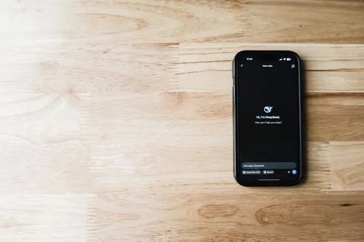 realistic smartphone privacy settings screen for AI app next to laptop admin console and checklist, office desk daylight, no readable brand marks | AI 앱 개인정보 설정과 관리자 콘솔을 점검하는 장면