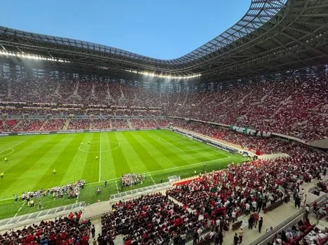 smartphone football score app showing Al Ain 4-0 Al Nassr final result, neutral UI without official logos, stadium desk scene | 스마트폰 스코어 앱에서 Al Ain 4-0 Al Nassr 최종 결과를 확인하는 장면