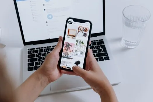 smartphone showing comment moderation and restrict account concept, Korean social media user at cafe realistic photo | 인스타 댓글 제한 기능을 확인하는 장면