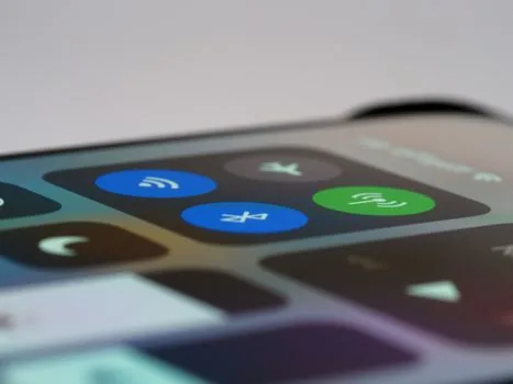 Smartphone volume slider muted before entering subway gate, wireless earbuds connected icon visible, realistic close-up | 지하철 개찰구 앞에서 스마트폰 볼륨과 이어폰 연결 아이콘을 확인하는 장면