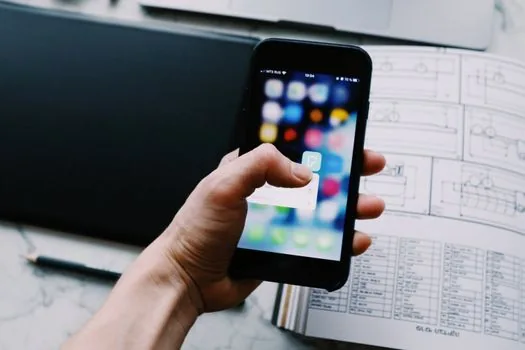 smartphone YouTube video player with autoplay toggle blurred, user turning off next video playback, realistic desk photo no logos
