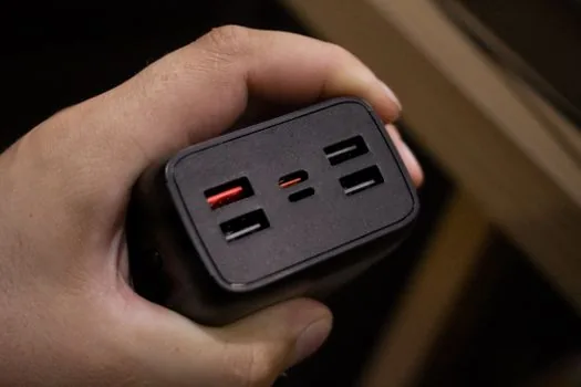 USB-C charger connected directly to laptop next to disconnected hub, realistic desk photo