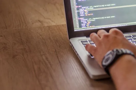 web developer viewing AI coding leaderboard and React preview on laptop in bright workspace