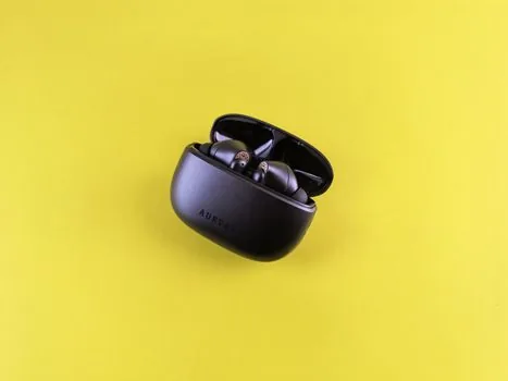Windows 11 laptop Bluetooth settings with wireless earbuds in open charging case | 노트북 옆 블루투스 이어폰을 페어링 모드로 준비한 장면