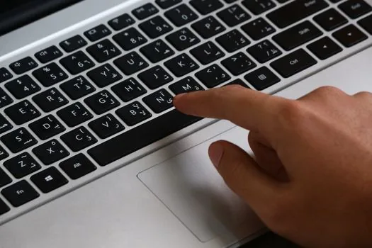 Windows 11 taskbar input language indicator and keyboard layout settings open on laptop, realistic clean desk photo | 입력 언어와 키보드 배열을 확인하는 장면